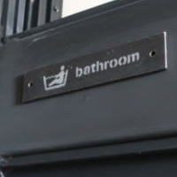 ドアのアクセントになる　お風呂用のシンプルなアイアンサインプレート